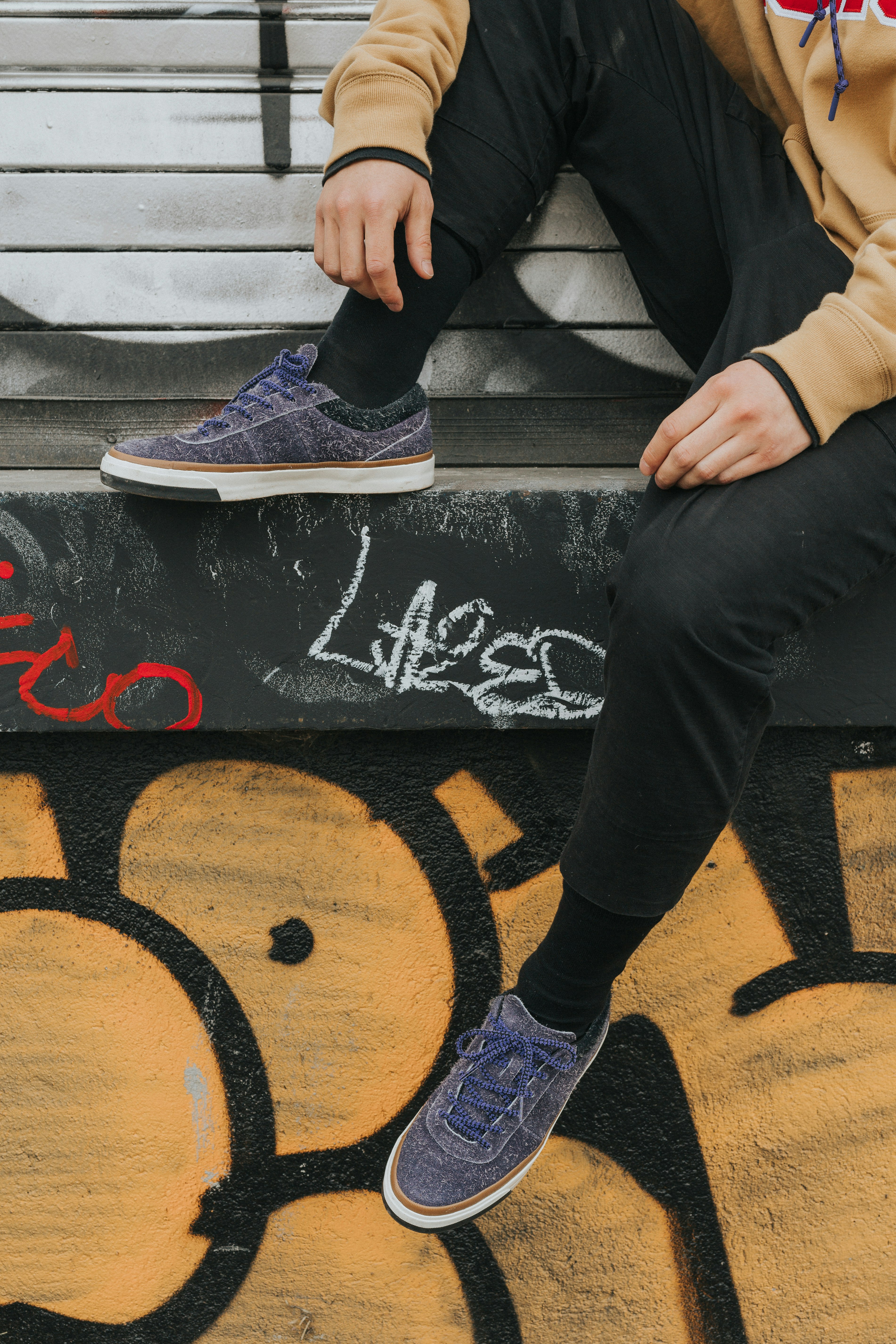 person sitting on gray concrete surface during daytime